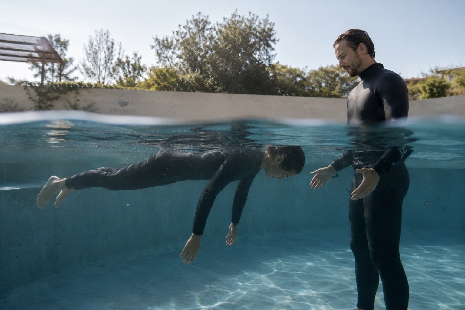 An instructor supporting a participant floating face down in the water