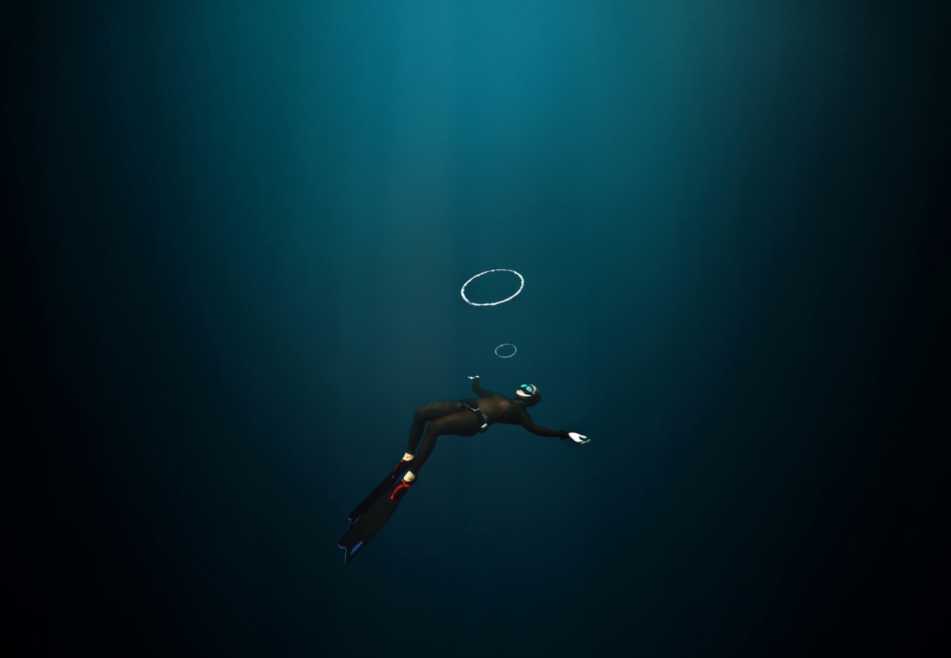 A freediver floating in deep blue water below bubble rings